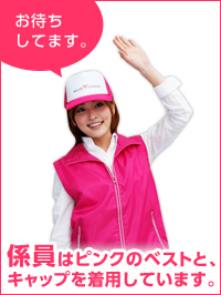 画像:係員は、ピンクのベストとキャップを着用しています